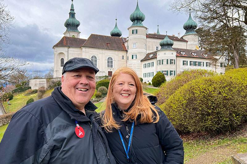 Two Dream Vacations Franchise Owners smiling outside a castle