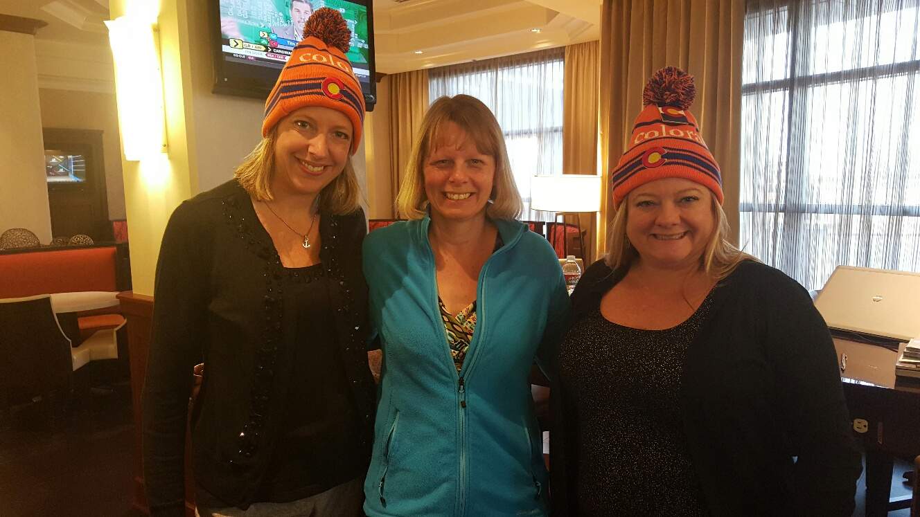 Three women posing for a photo in a small lounge.