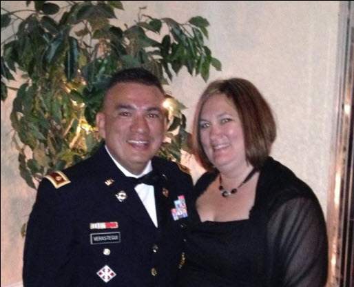 Man in military uniform posing for a photo with a woman.