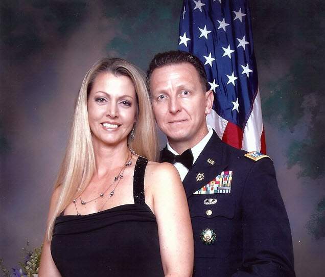 Military member with a spouse taking a photo with U.S. flag.