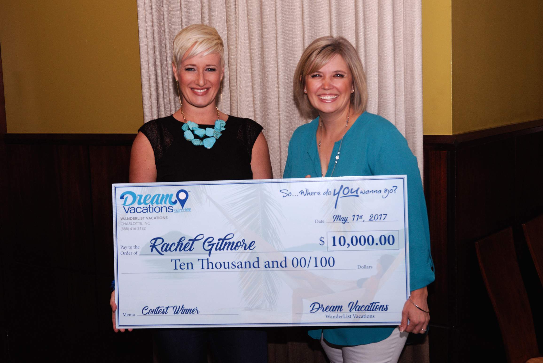 Two women holding up a giant check from Dream Vacations.