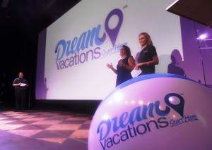 Three people on stage presenting on Dream Vacations.
