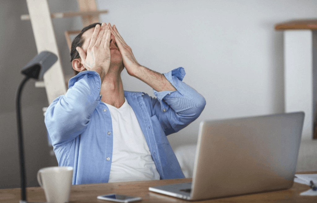 Man sitting at computer overwhelmed