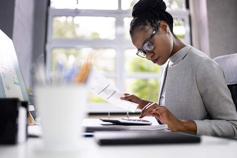 Woman with glasses going through papers, working and pursuing home based travel business goals