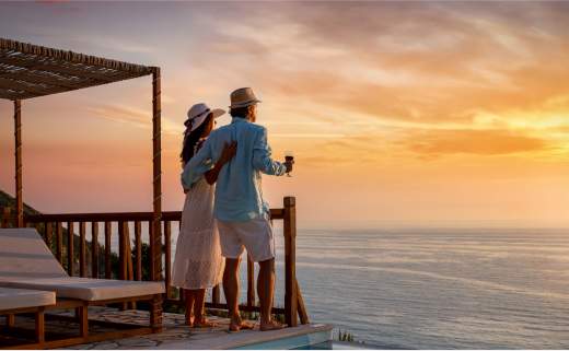 A couple gazing out on the ocean from a veranda