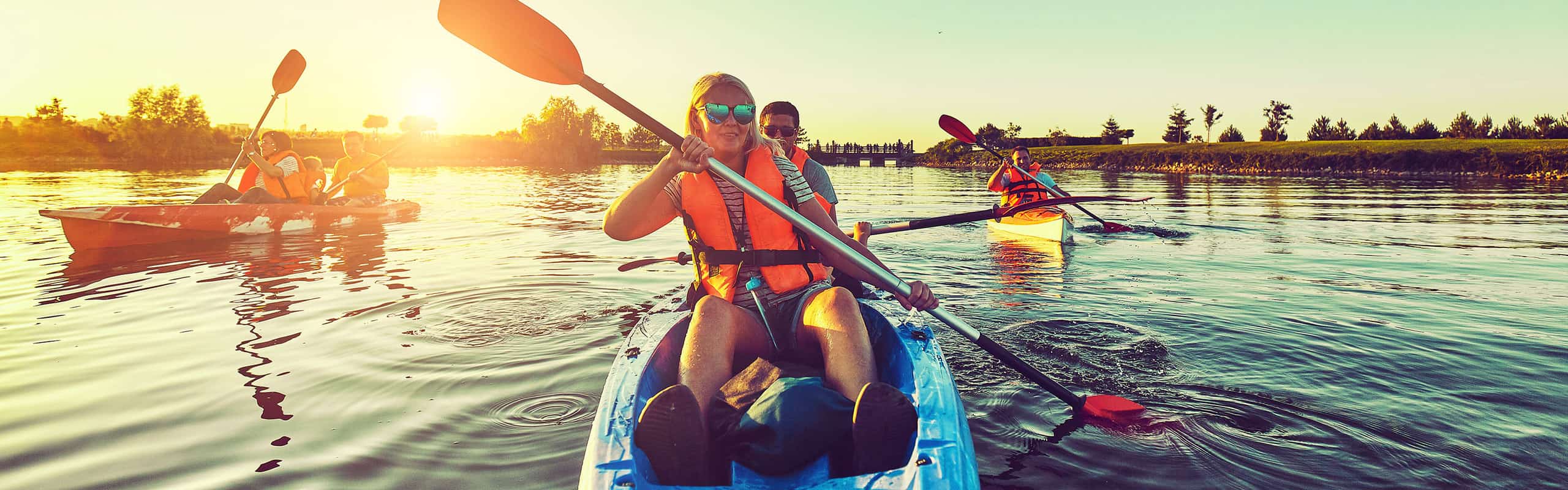 People kayaking at sunset -- find your own travel agency marketing strategy