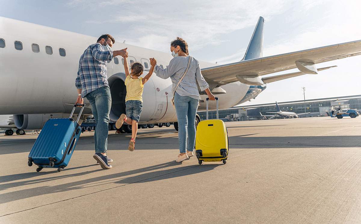 Family walking to an airplane - what are the different types of travel agencies?