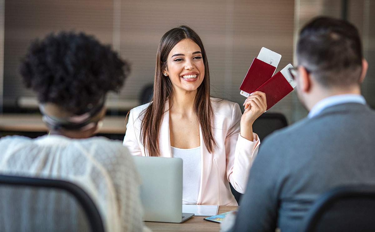 Woman holding tickets helping prospects weigh the benefits of a travel franchise vs host agency