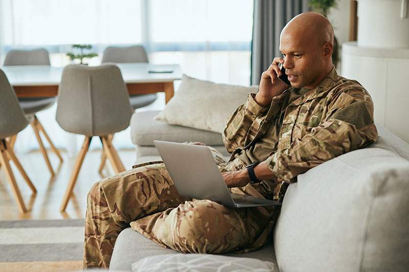 Elderly man in military fatigues on phone and PC - are there any incentives for veteran franchisees?
