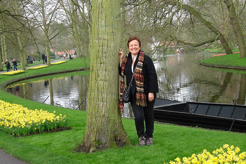 woman leaning on tree, lake behind her thinking how to become a franchisee