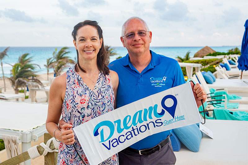 man and women on beach holding dream vacations sign - how to start a veteran owned business