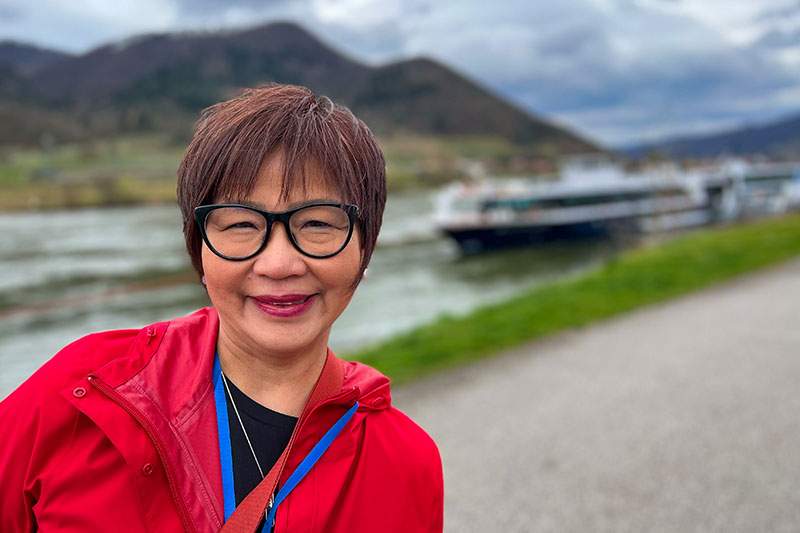 Dream Vacations franchisee in front of a small boat