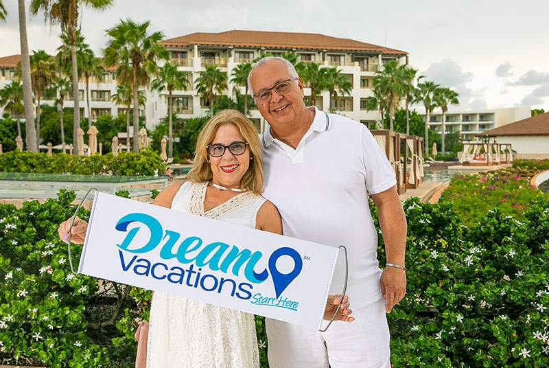man and woman holding a Dream Vacations sign