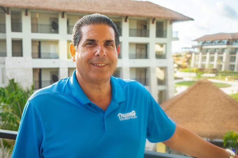 A man in a blue shirt stands on a balcony