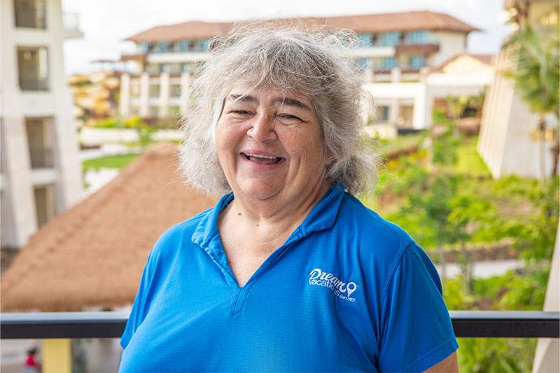 A woman in a blue shirt smiling