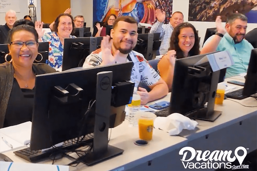 people at computers waving